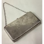 A large Russian silver purse with green stone and engraved decoration.