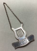 A lyre shaped silver wine label for 'Port'.