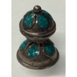 A silver pomander with green stone decoration.