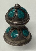 A silver pomander with green stone decoration.