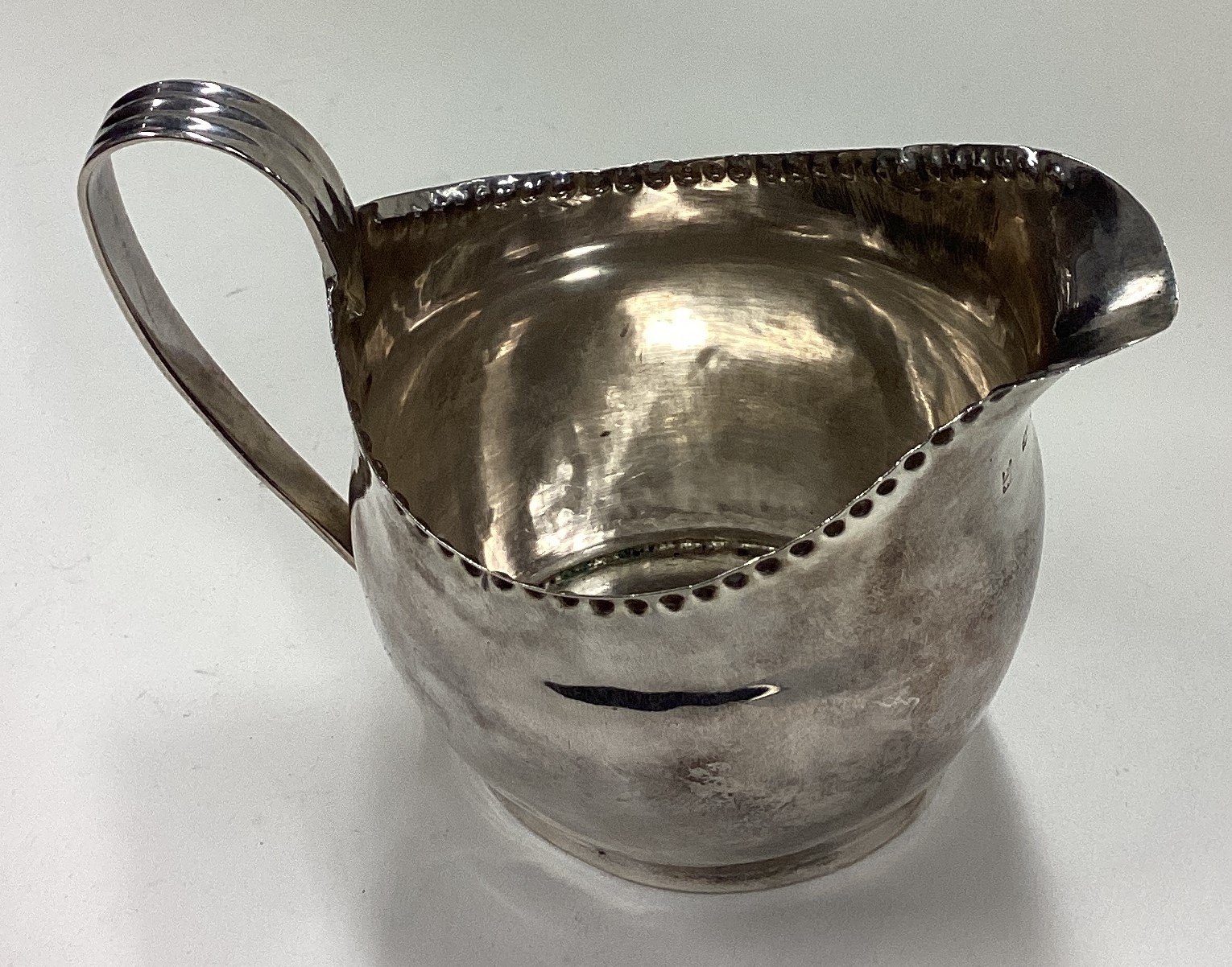 A George III silver cream jug with beaded border. - Bild 2 aus 2