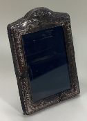 A silver picture frame with swag decoration.