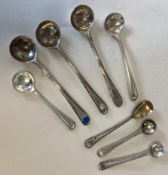 A large collection of silver salt spoons with beaded decoration.