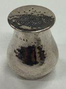 An Arts and Crafts silver pepper pot. London 1925.
