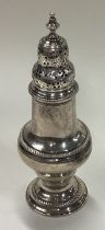 A George III silver caster with lift-off cover.