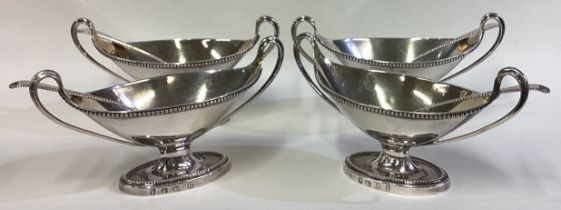 A find set of four George III silver twin-handled salts with spoons.