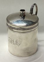 A George III silver bougie box with wax candle inside.