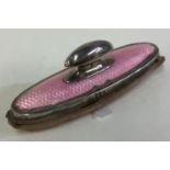 A silver and pink enamelled nail buffer.