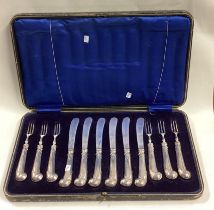 A boxed set of six plus six silver mounted cake knives and forks.