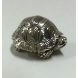 A heavy silver pill box with hinged lid in the form of a tortoise.