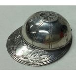 A silver caddy spoon in the form of a jockey cap.