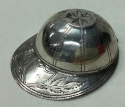 A silver caddy spoon in the form of a jockey cap.