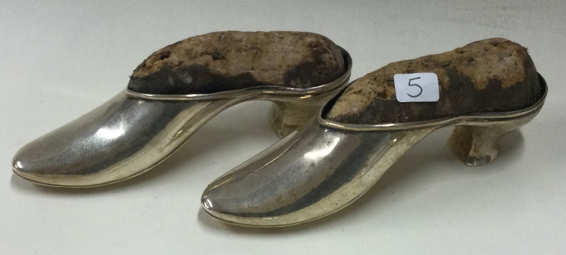 A good pair of silver pin cushions in the form of shoes.