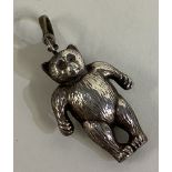 A silver rattle in the form of a teddy bear.