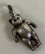 A silver rattle in the form of a teddy bear.