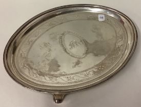 A silver teapot stand with bright-cut decoration.