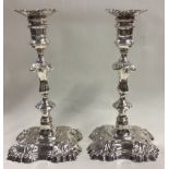 A fine pair of George II cast silver candlesticks.