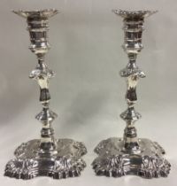 A fine pair of George II cast silver candlesticks.