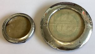 Two circular silver mounted picture frames.