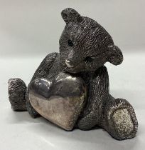 A novelty silver figure of a teddy bear with heart.