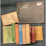 A collection of leather-bound books and cigarette cards.