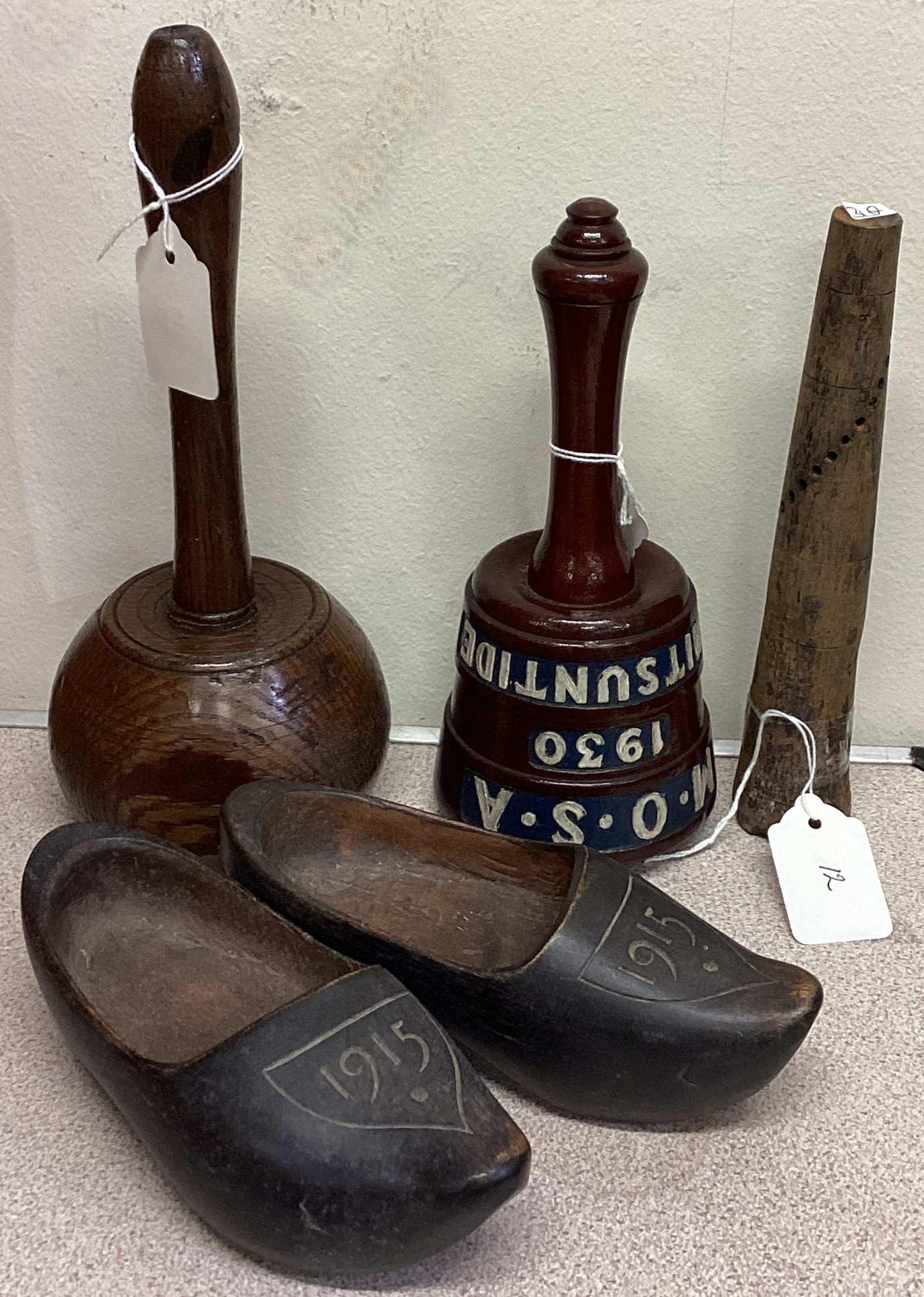 An old Torrington Post Office mallet together with one other, a pair of clogs and a shell fuse.