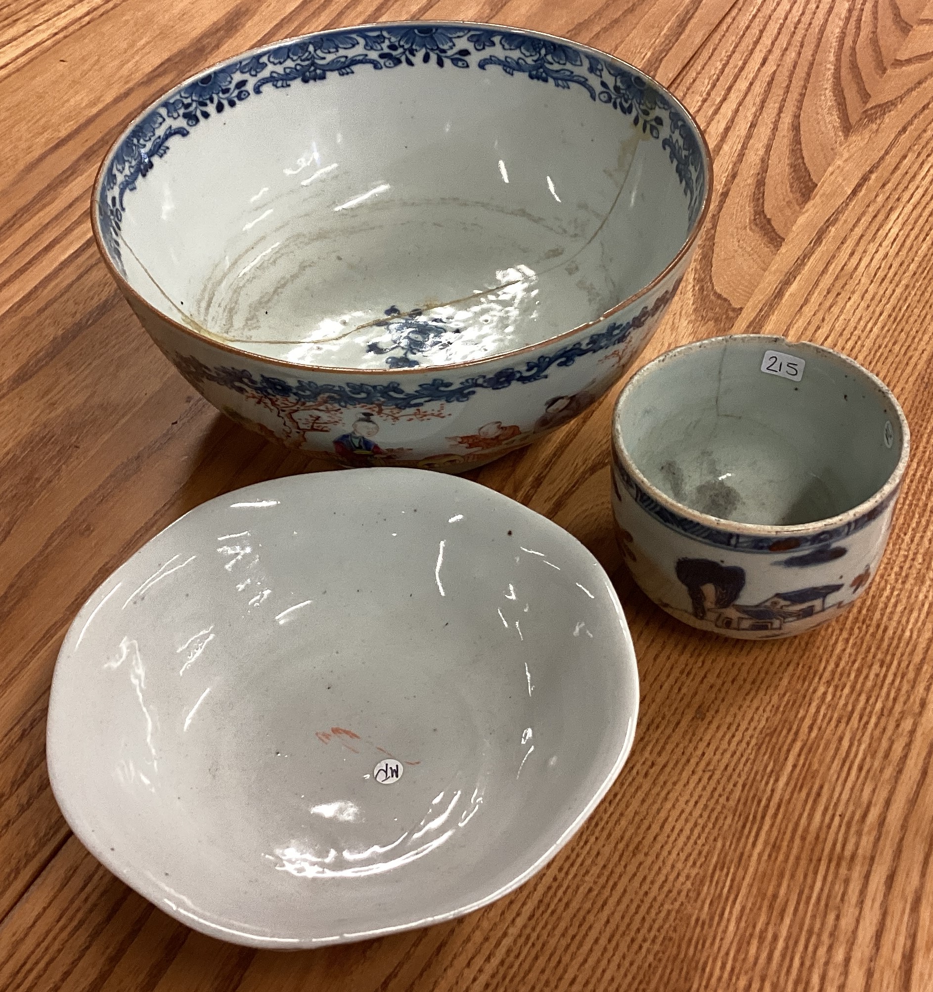 A circular Chinese bowl decorated with bright colours together with two others.