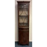 A narrow mahogany bookcase.