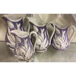 A group of four graduating Staffordshire lustreware lilac ceramic jugs with tulip pattern.