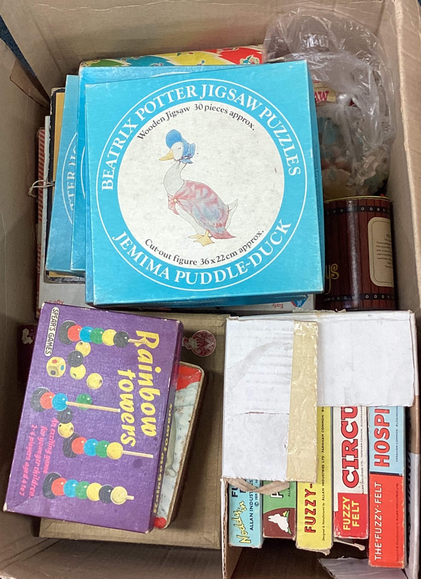 A box containing old children's games including Fuzzyfelt, Beatrix Potter jigsaw puzzle etc.