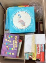 A box containing old children's games including Fuzzyfelt, Beatrix Potter jigsaw puzzle etc.