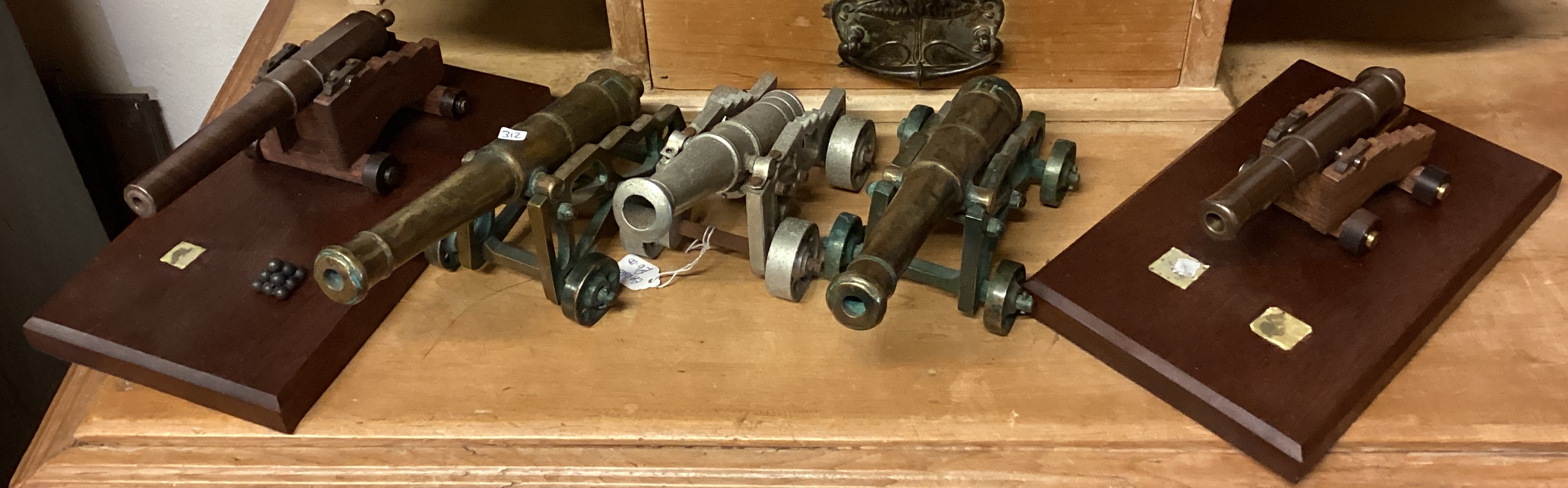 Three brass mounted cannons together with two other model cannons.