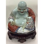 A large Chinese figure of a Buddha on hardwood stand.