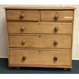 A stripped pine chest of five drawers.