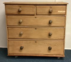 A stripped pine chest of five drawers.