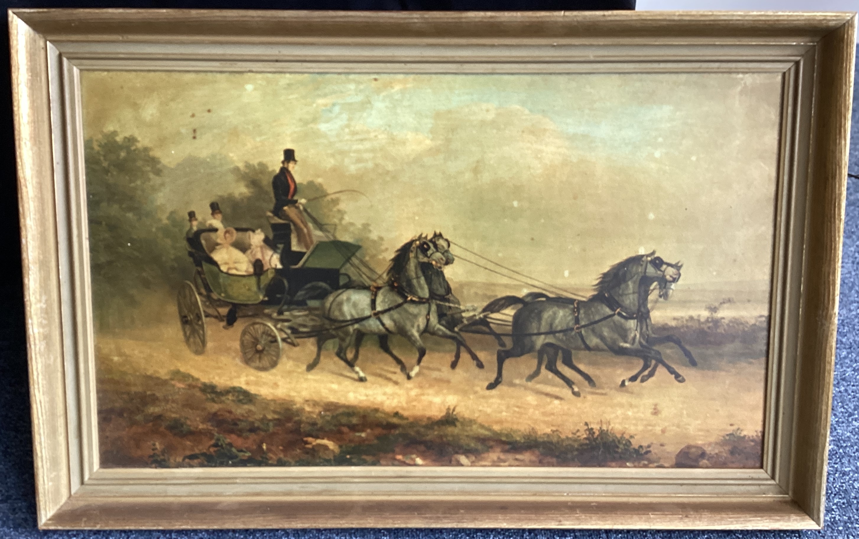 A framed picture depicting horses and carriage.