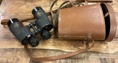 A pair of military binoculars in carrying case.