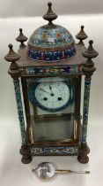 A large Continental brass and enamelled clock decorated in bright colours.