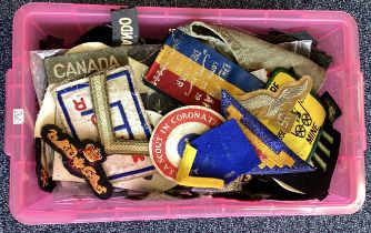 A large box containing old fabric badges.