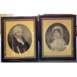 A pair of framed and glazed portraits of a lady and a gentleman in oval mounts.