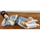 A good Japanese figure of a lady in recumbent position.