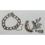 A silver curb link bracelet together with a silver horseshoe brooch with charms.