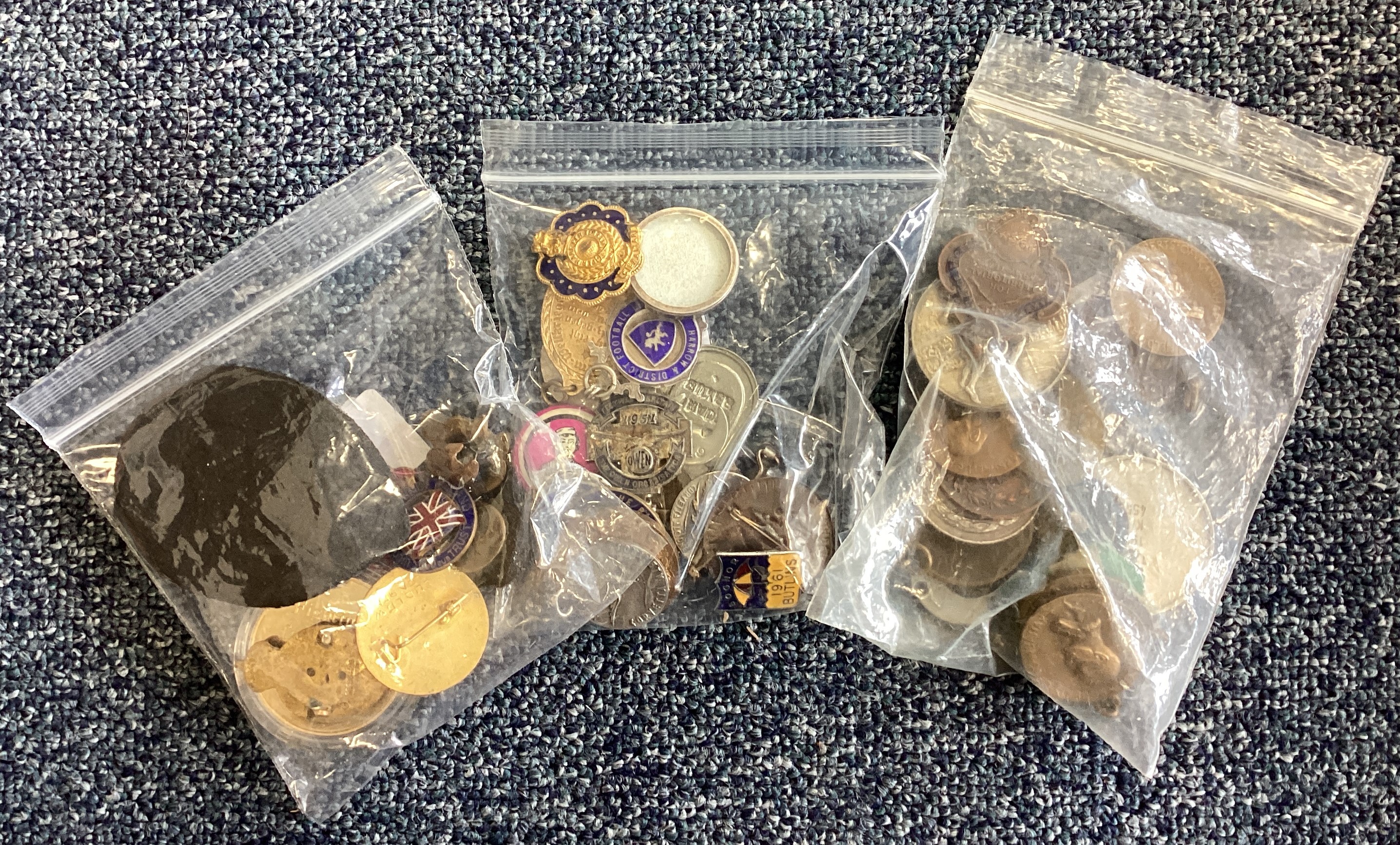 Three bags of assorted medals and badges.