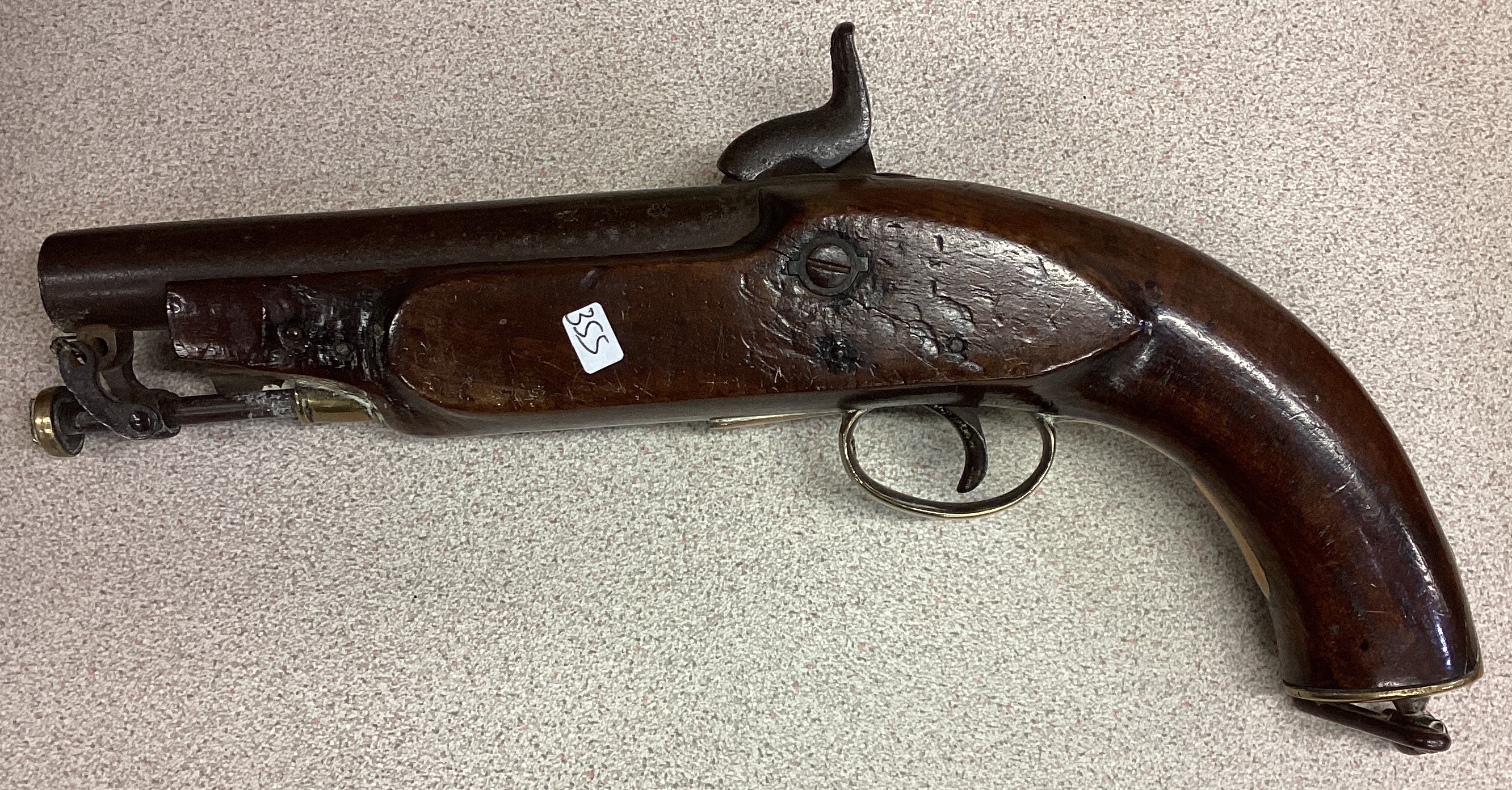 An old oak and brass mounted flintlock pistol.
