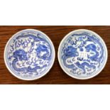 A pair of Chinese miniature blue and white dishes with dragon decoration. Signed to base.