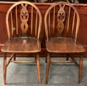 A pair of oak wheel back chairs.
