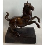 A bronze figure of a rearing horse mounted on wood plinth.