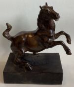 A bronze figure of a rearing horse mounted on wood plinth.