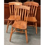 A group of three stick back chairs.