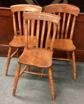 A group of three stick back chairs.